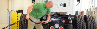 man pulling a chain in a vehicle testing lab