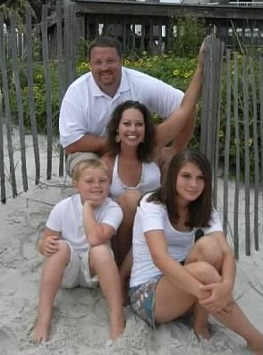 Dawn King and her family sit in the sand at the beach