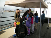 Students perform water quality experiments with EPA staff at the Canoemobile Event at the Charlestown Navy Yard. Students used USGS test kits to measure temperature, pH and turbidity.