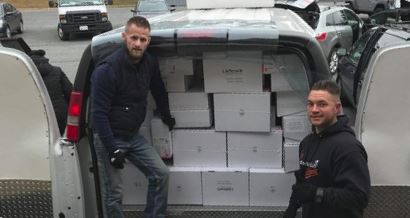 This is a picture of two men loading food donations into a van.