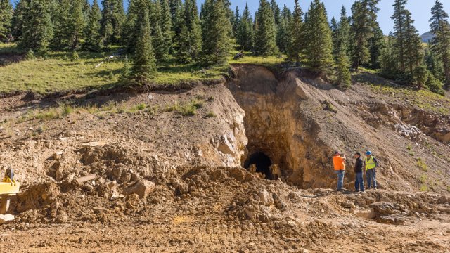 side of a hill with a large opening and lots of excavation