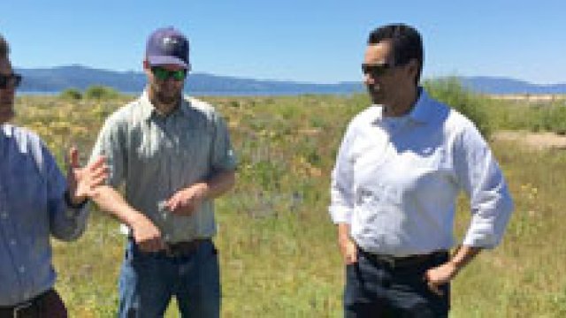 Four men in conversation with Lake Tahoe in the background