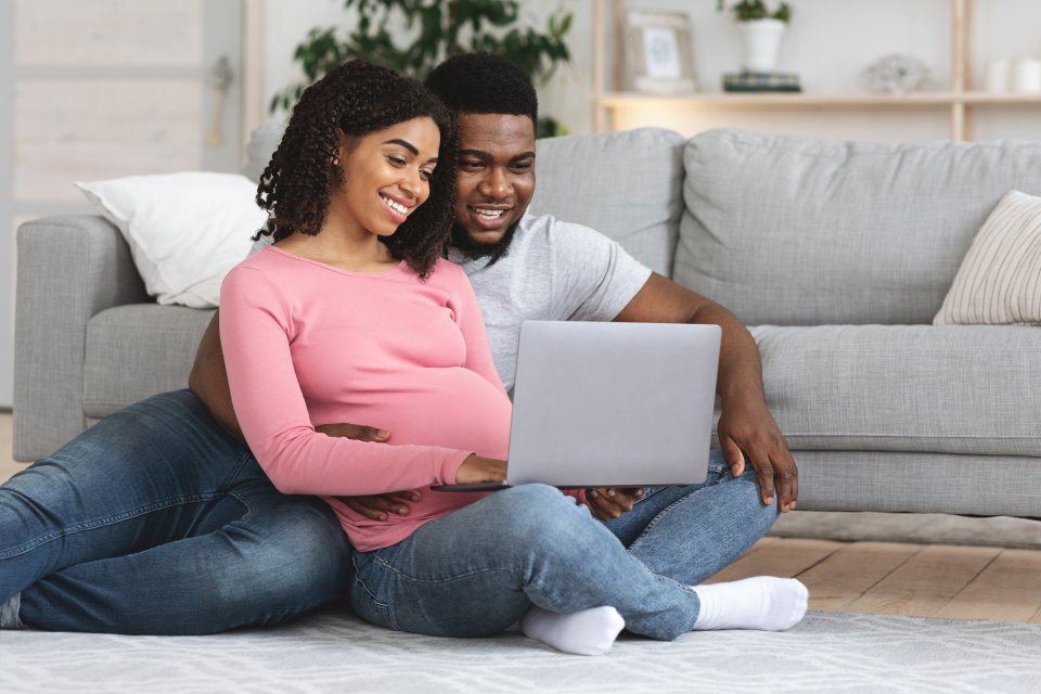 couple on floor looking at a laptop computer screen