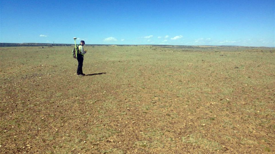 EPA contractor with backpack standing in a flat desert area