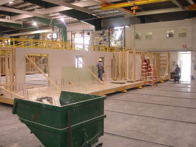 Workers on factory floor building a modular home.