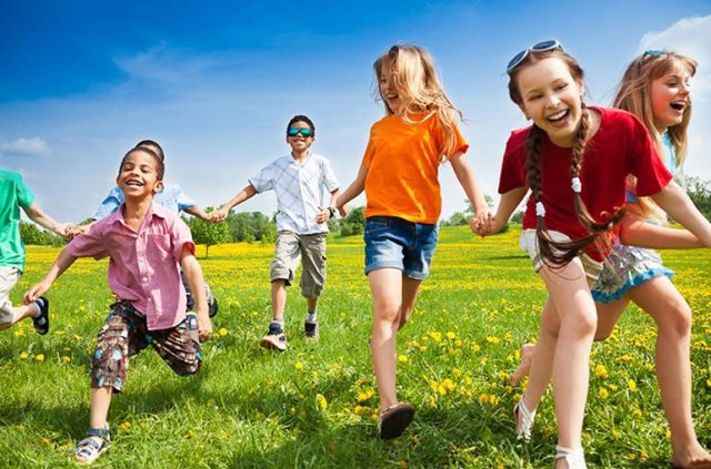 Children laughing and playing on grass