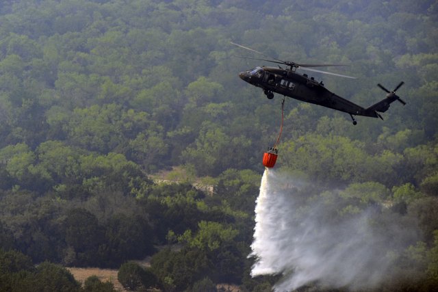 Helicopter releasing water on wildfire