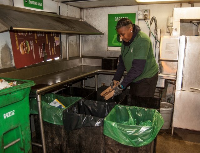 This is a picture of a woman recycling cardboard