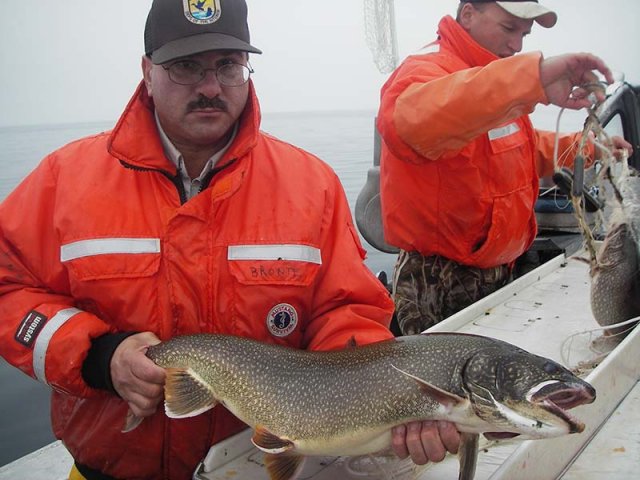 researcher on a boat holding a fish