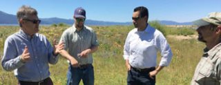 Four men in conversation with Lake Tahoe in the background