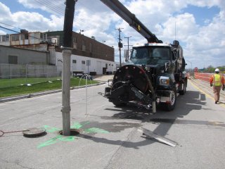 Vacuum truck with high pressure pump cleaning out the storm sewer line along the service drive