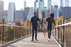 a family walks on a foot bridge in a city