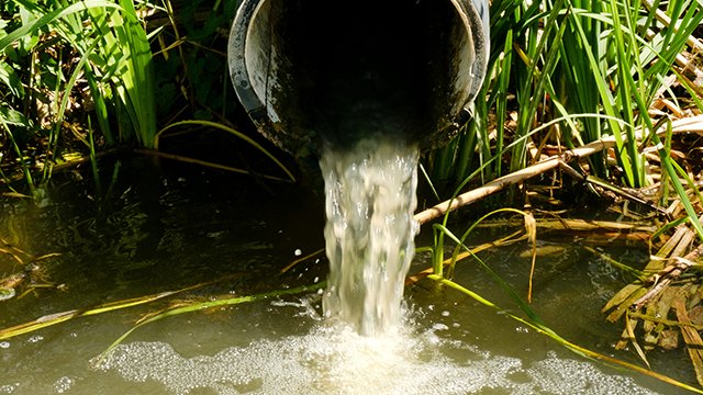 Sewage pipe discharges sewage and wastewater into the river.