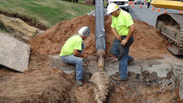 Workers laying sewer pipes