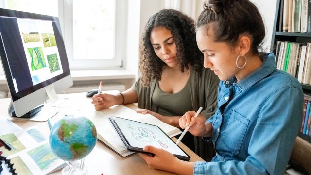 people looking at papers with globe