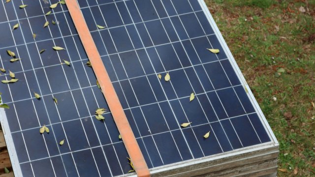 Pile of used solar panels strapped together. 