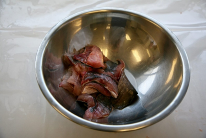 Small pieces of fish fillet in a stainless steel bowl.