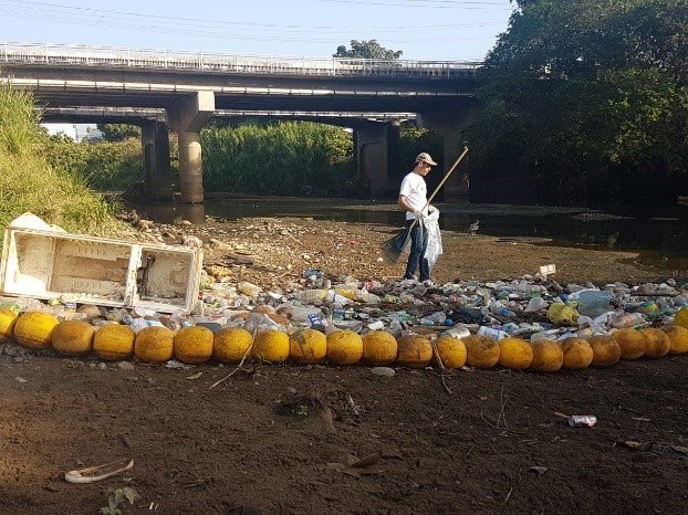 a man collecting trash in a waterway