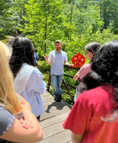 Wilson Salls holds a Secchi disk while leading a water sensor workshop for SSI students.