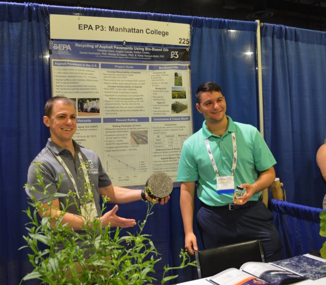 3.	Two students from the Manhattan College team holding up a cylinder of asphalt, part of their project on sustainable recycling of asphalt pavement.