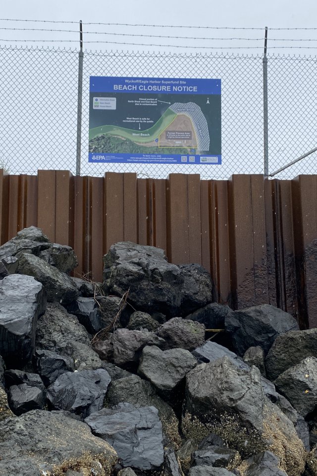 Sign showing beach closure areas posted at the site.