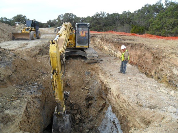 Front loader digging up contamination.