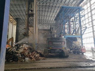 Interior of Segment 3 smelter building showing workers water misting interior