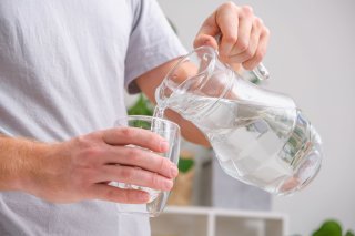 Person pouring a glass of water