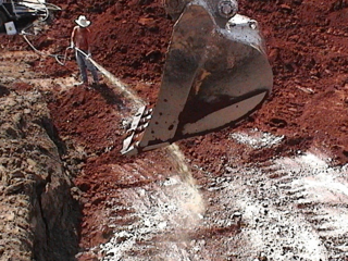 Man spraying oxygen releasing compound slurry on contaminated soil.