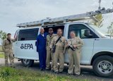 Five people standing in front of a white van with "EPA" on its side.