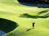 golfer hitting ball toward tee on golf course